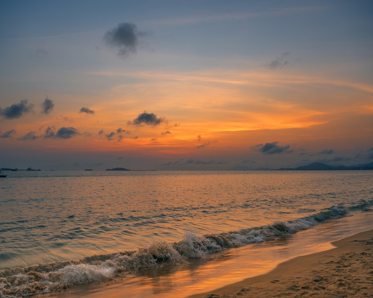 Морские волны омывают берег на закате