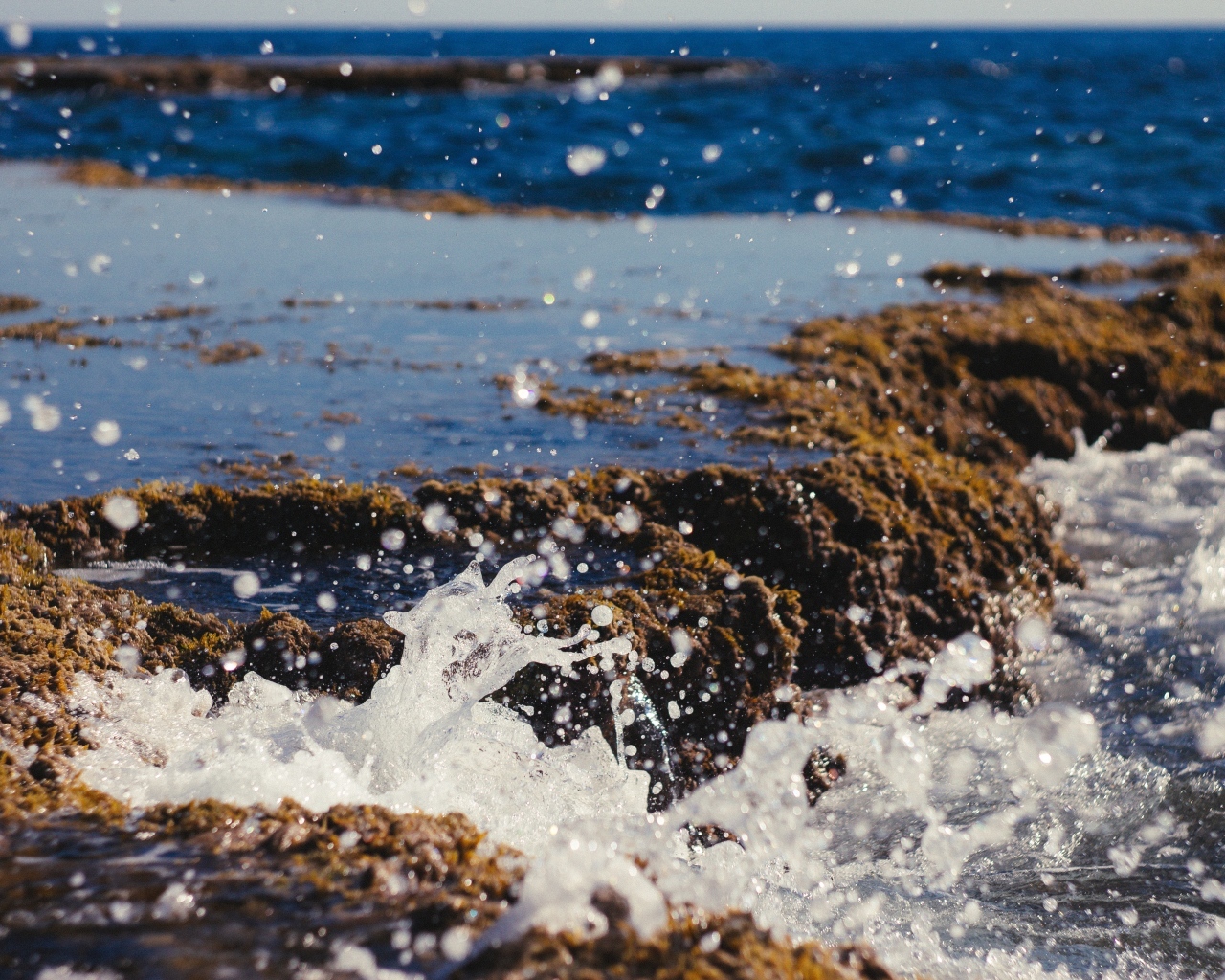 Брызги холодной морской воды на берегу