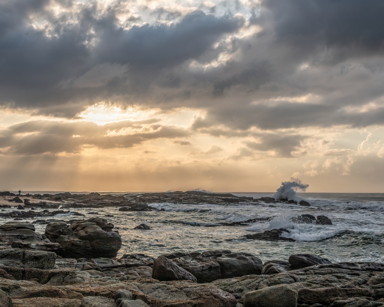 Лучи солнца пробиваются сквозь тучи над морем