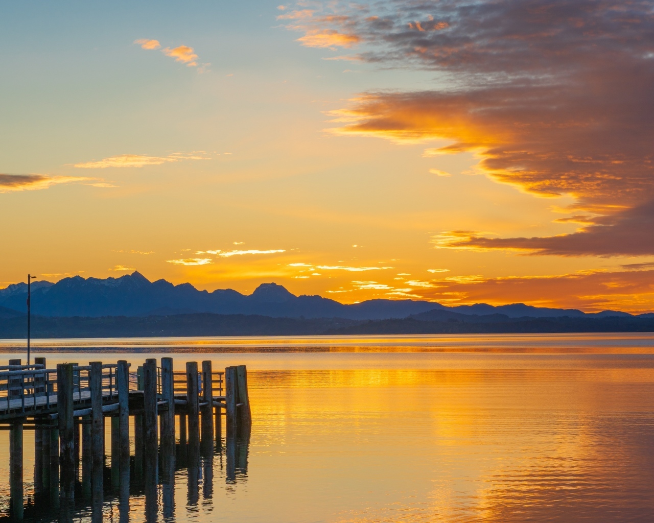 Красивый закат в небе над тихой водой озера