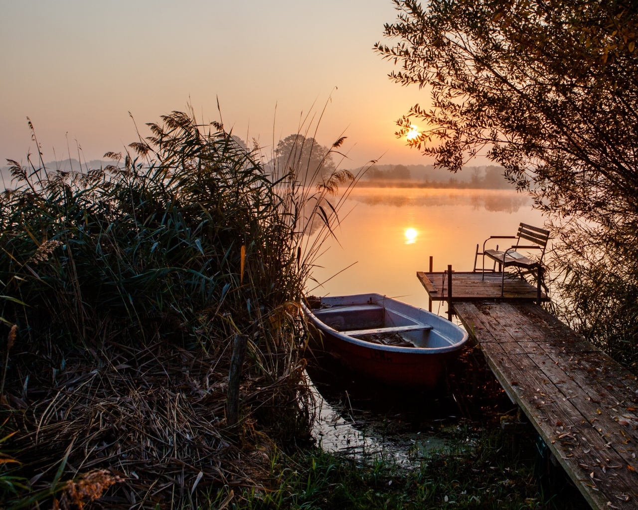 Лодка на берегу озера на закате 