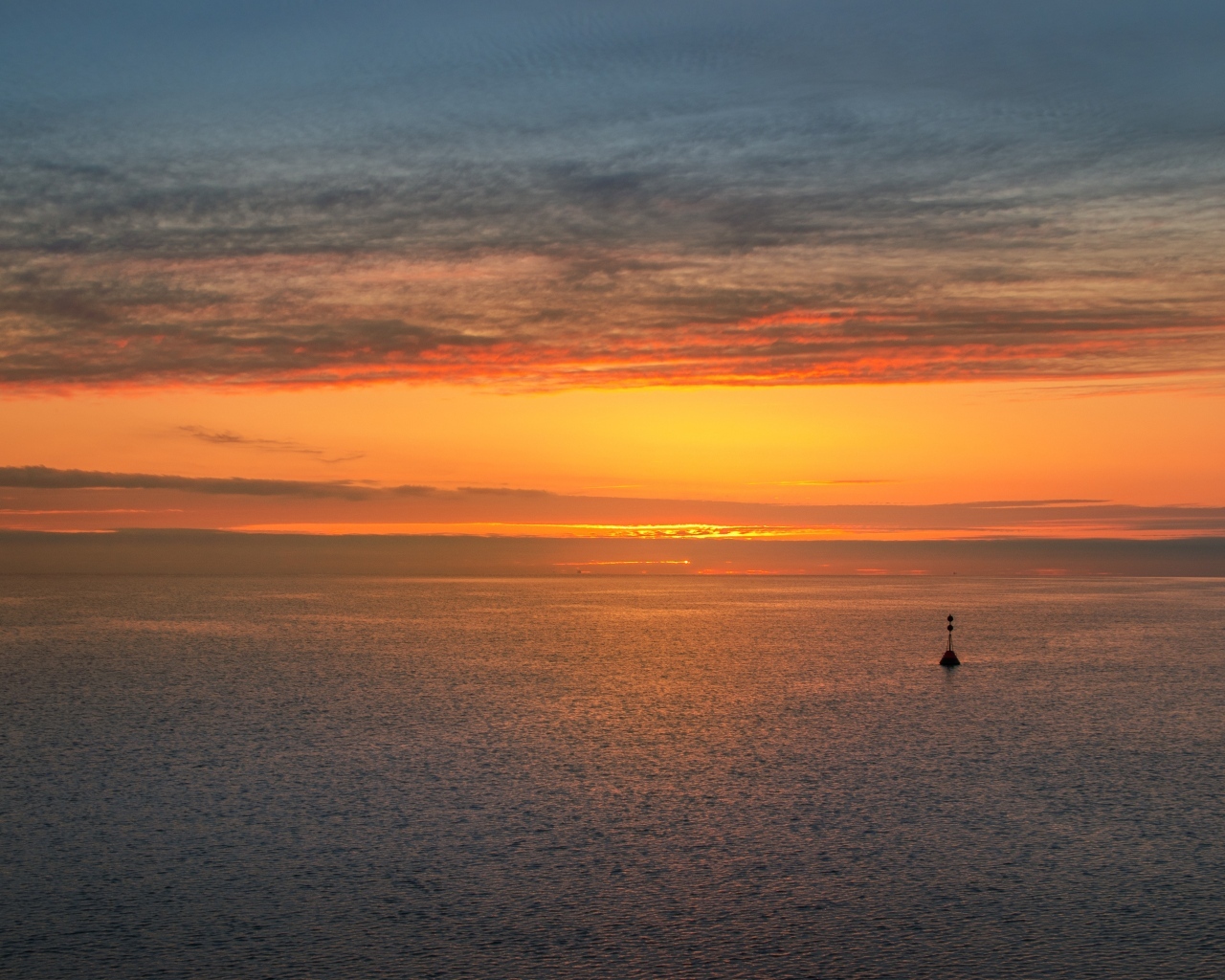 Яркий оранжевый закат на морском горизонте
