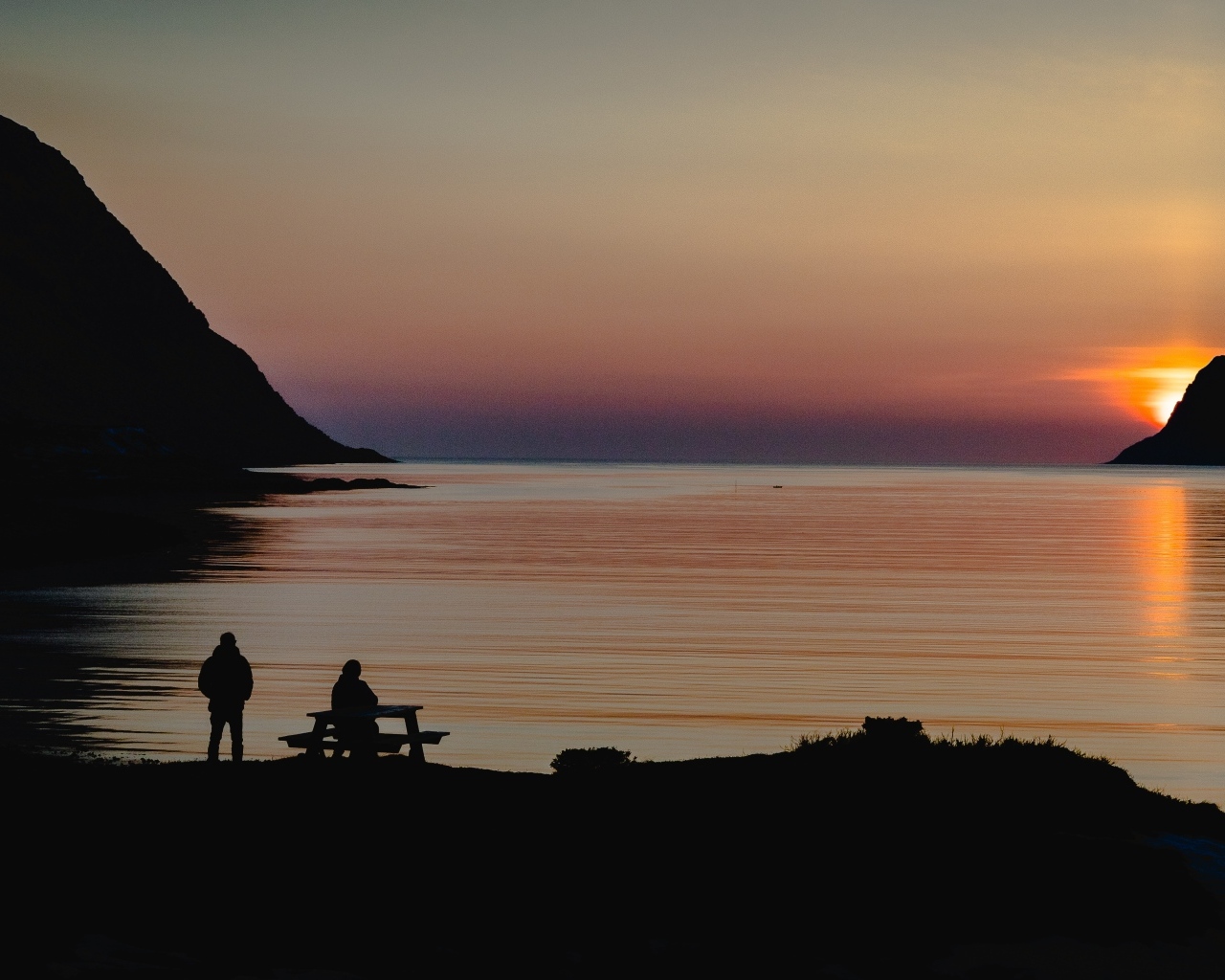 Солнце скрывается за горой в заливе