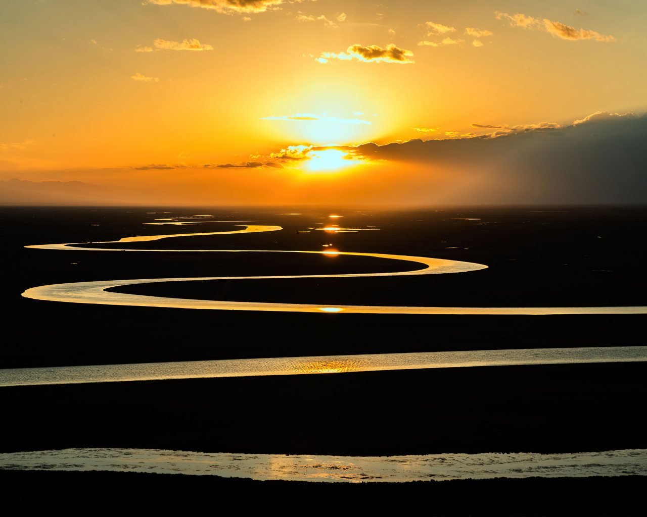 Извилистая река в лучах солнца на закате