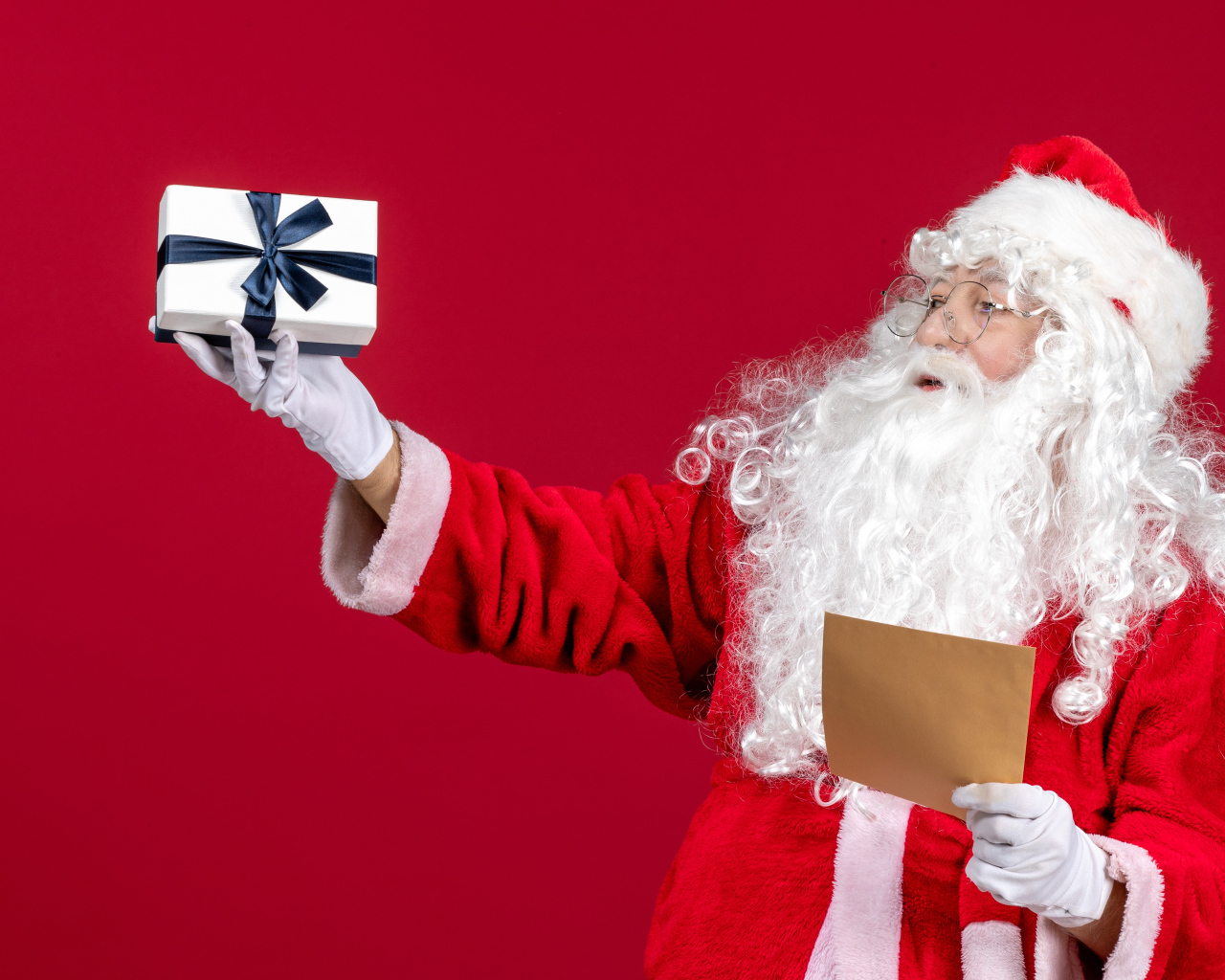 Санта Клаус с письмом на красном фоне