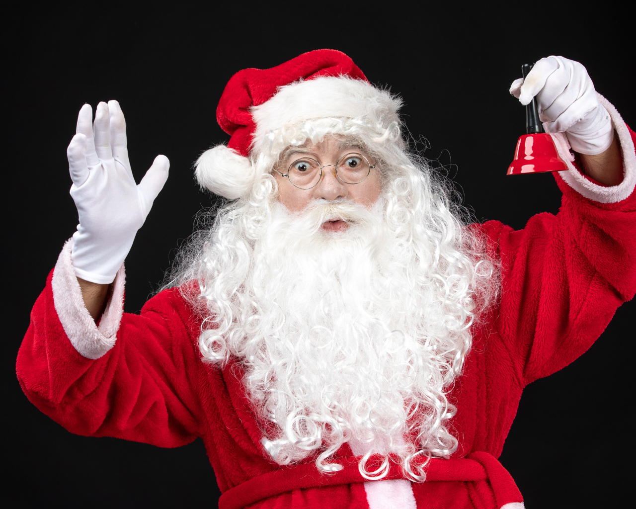 Удивленный Санта Клаус с колокольчиком в руках