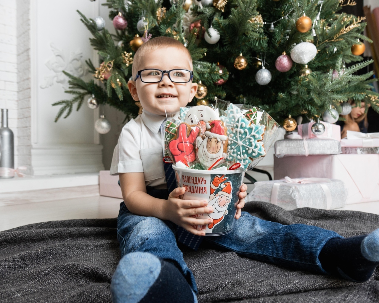 Маленький мальчик с печеньем сидит у ели