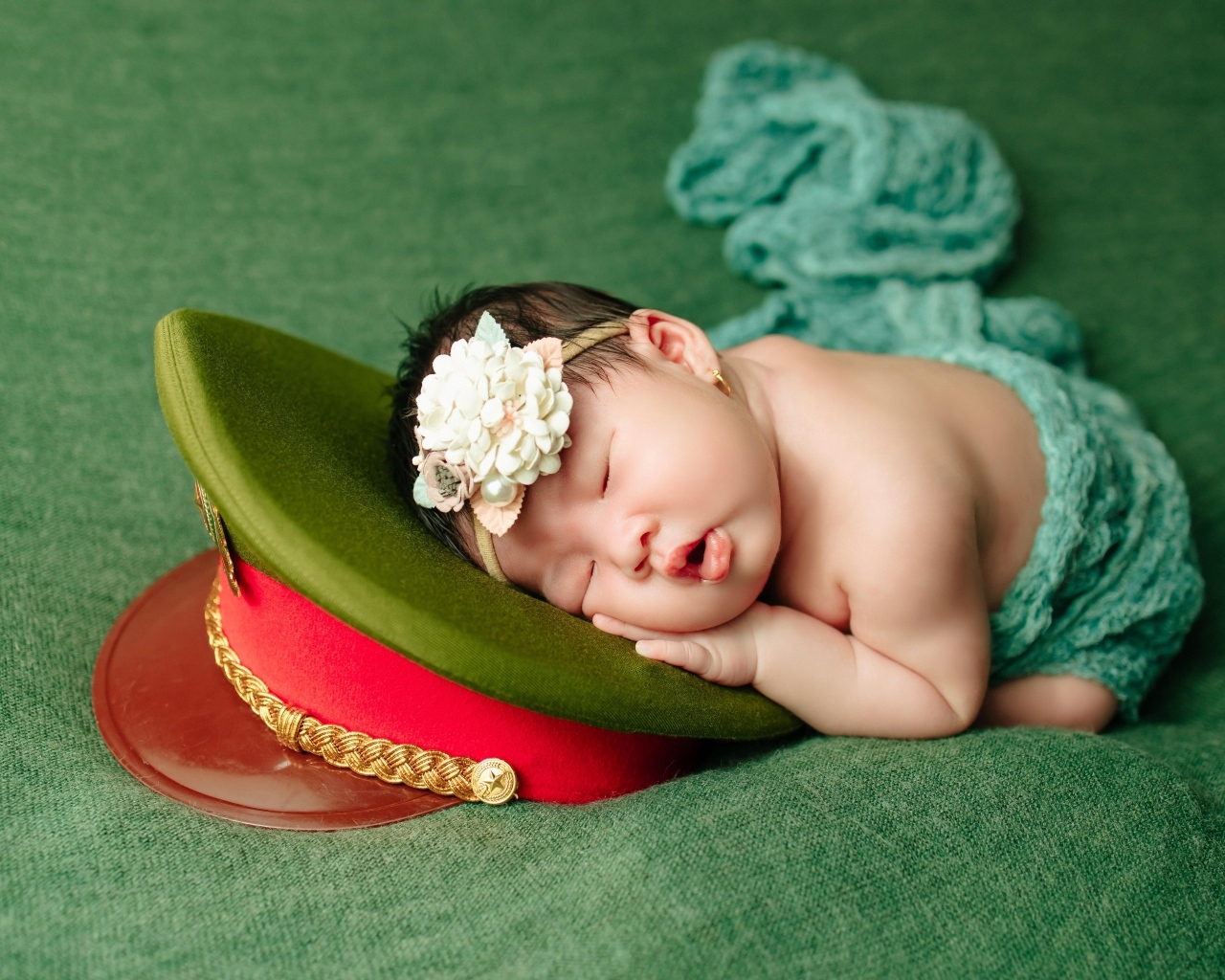 Маленький ребенок спит на военной фуражке