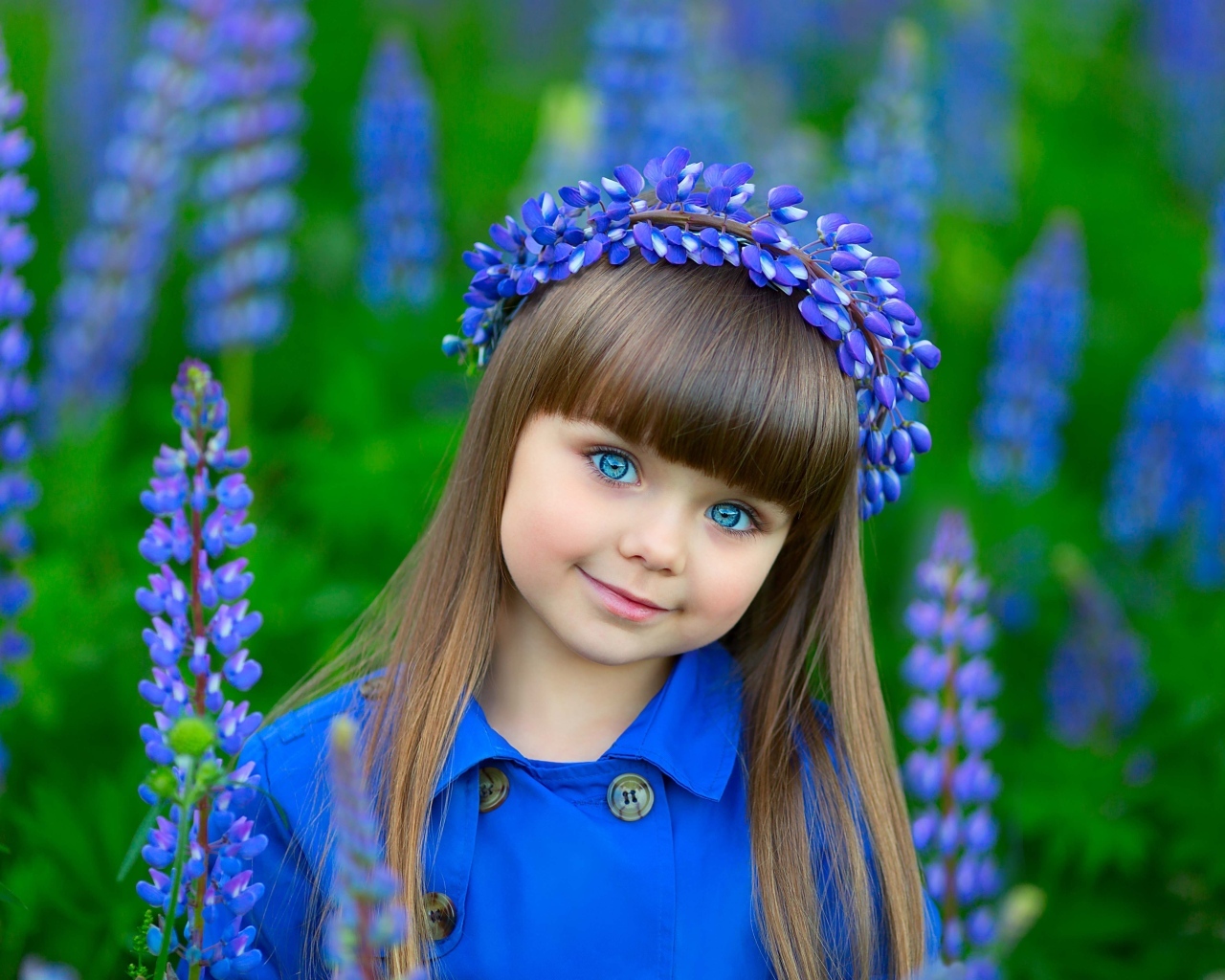 Красивая маленькая девочка в цветах люпина