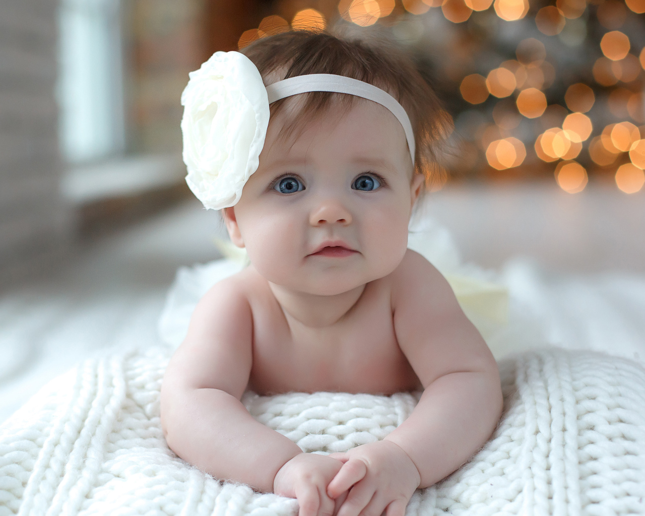 Красивая маленькая девочка с белым цветком на голове