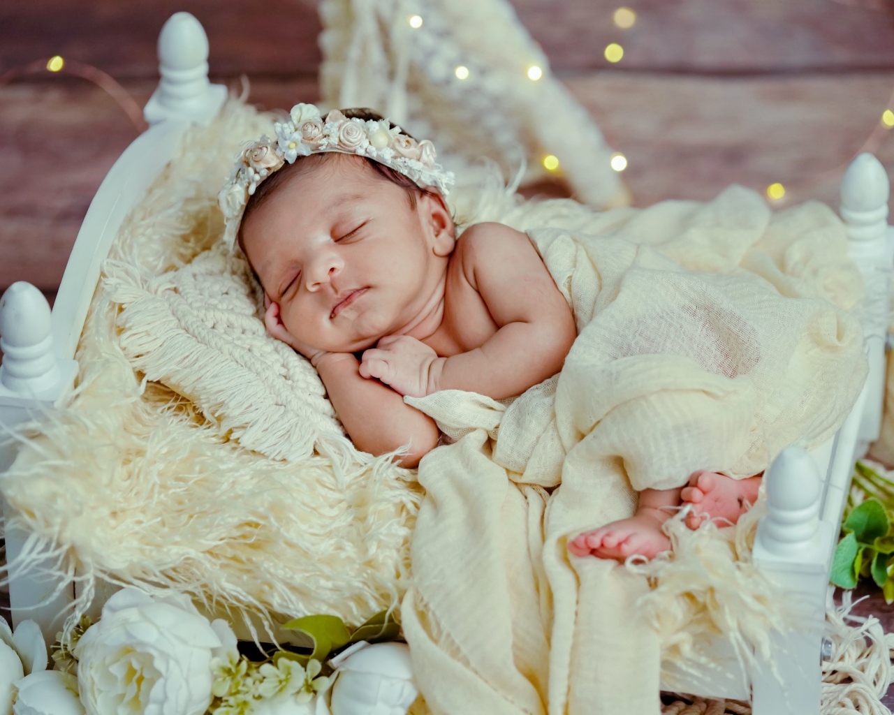 Красивая новорожденная девушка с венком на голове 
