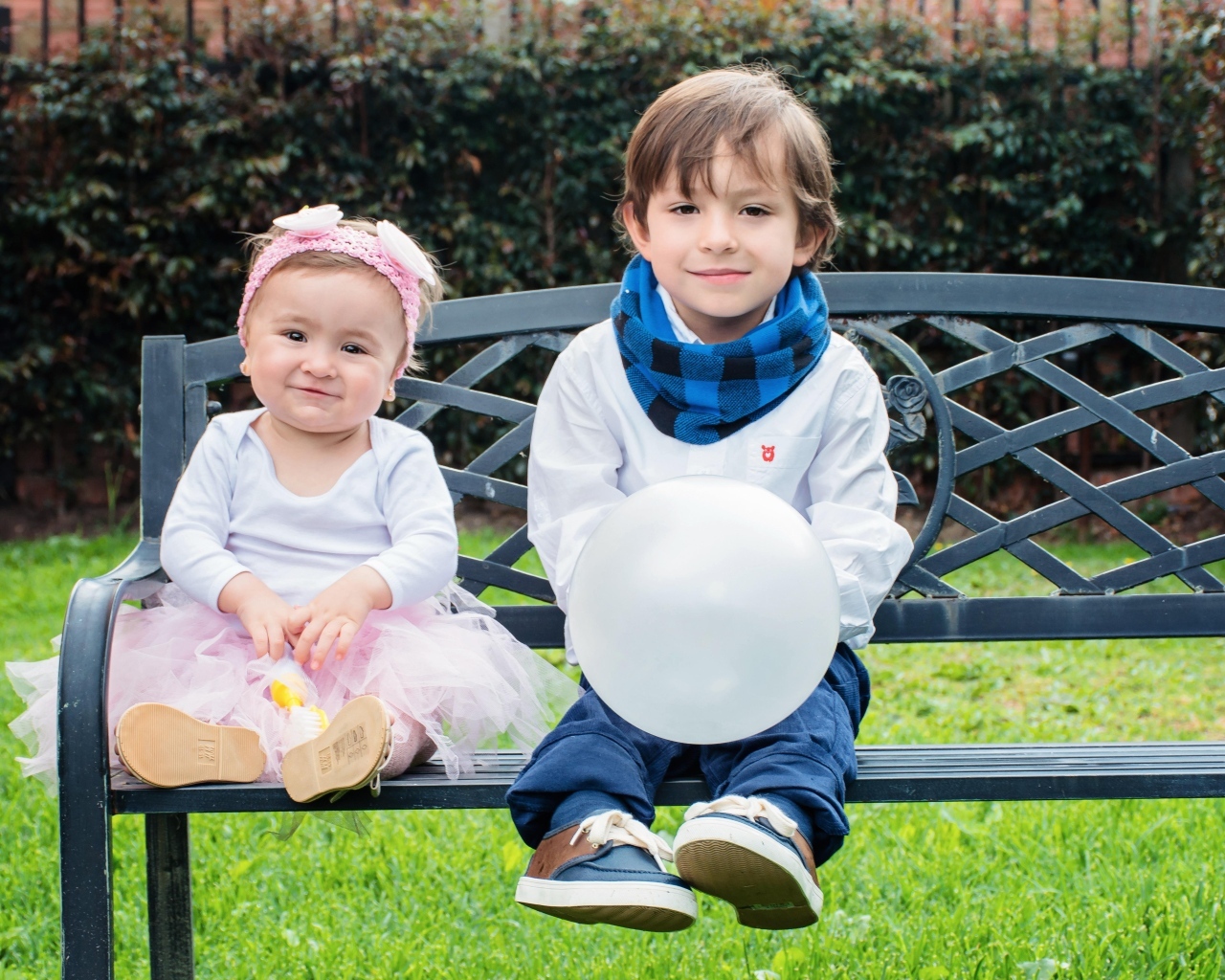Мальчик и девочка сидят на лавке в парке