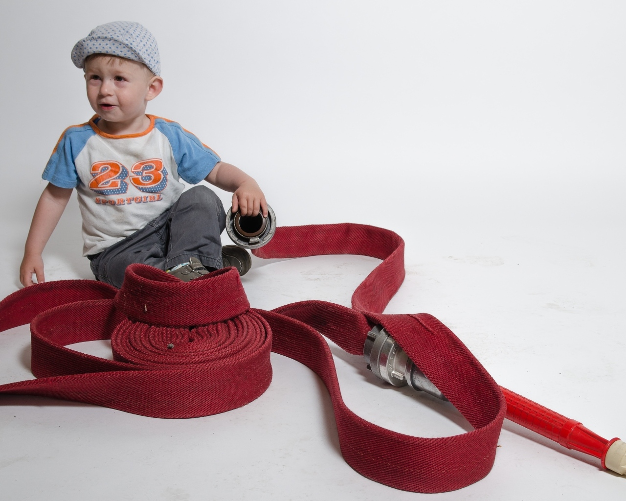 Мальчик с красным пожарным шлангом