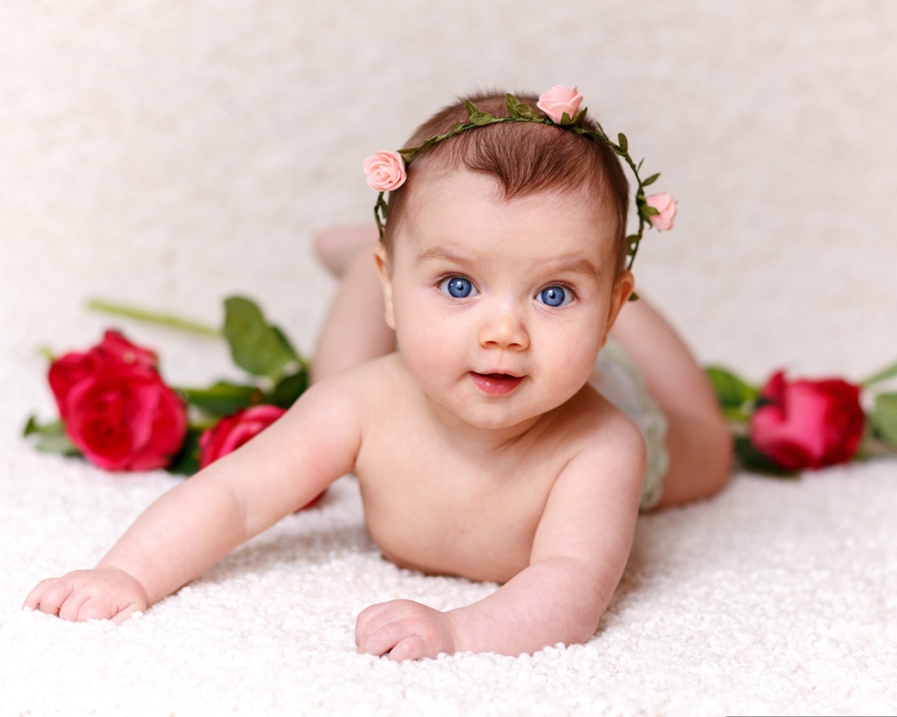 Милая голубоглазая малышка с цветами роз