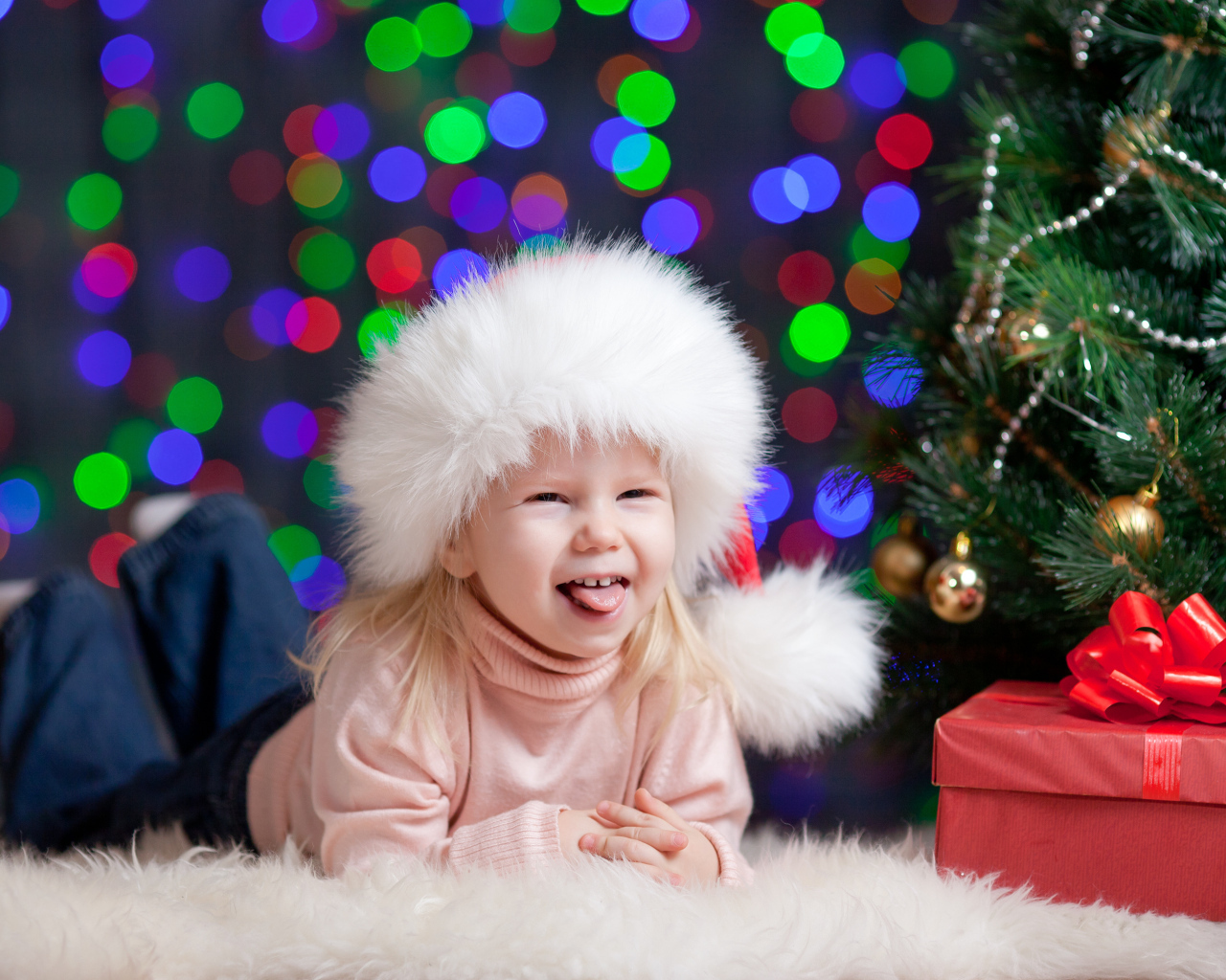 Смешная девочка у новогодней ели