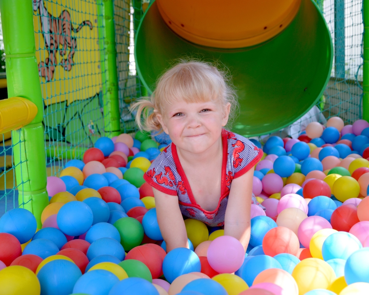 Забавная девочка играет в шариках