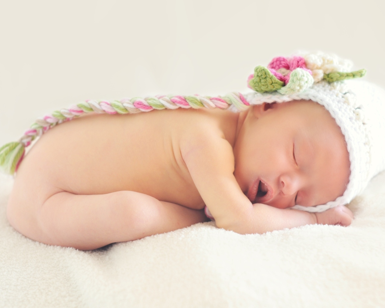 Нежный спящий ребенок в вязаной шапке 