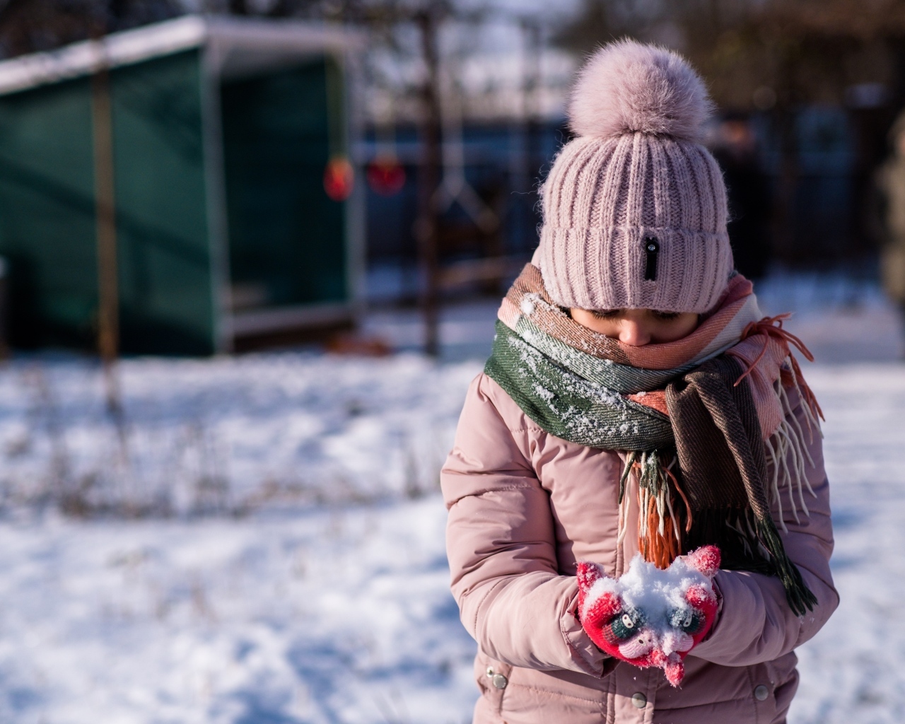 Девочка держит снег в руках зимой