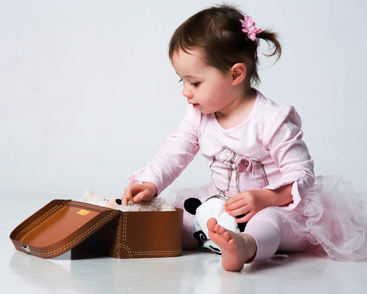 Девочка в розовом наряде с маленьким чемоданом