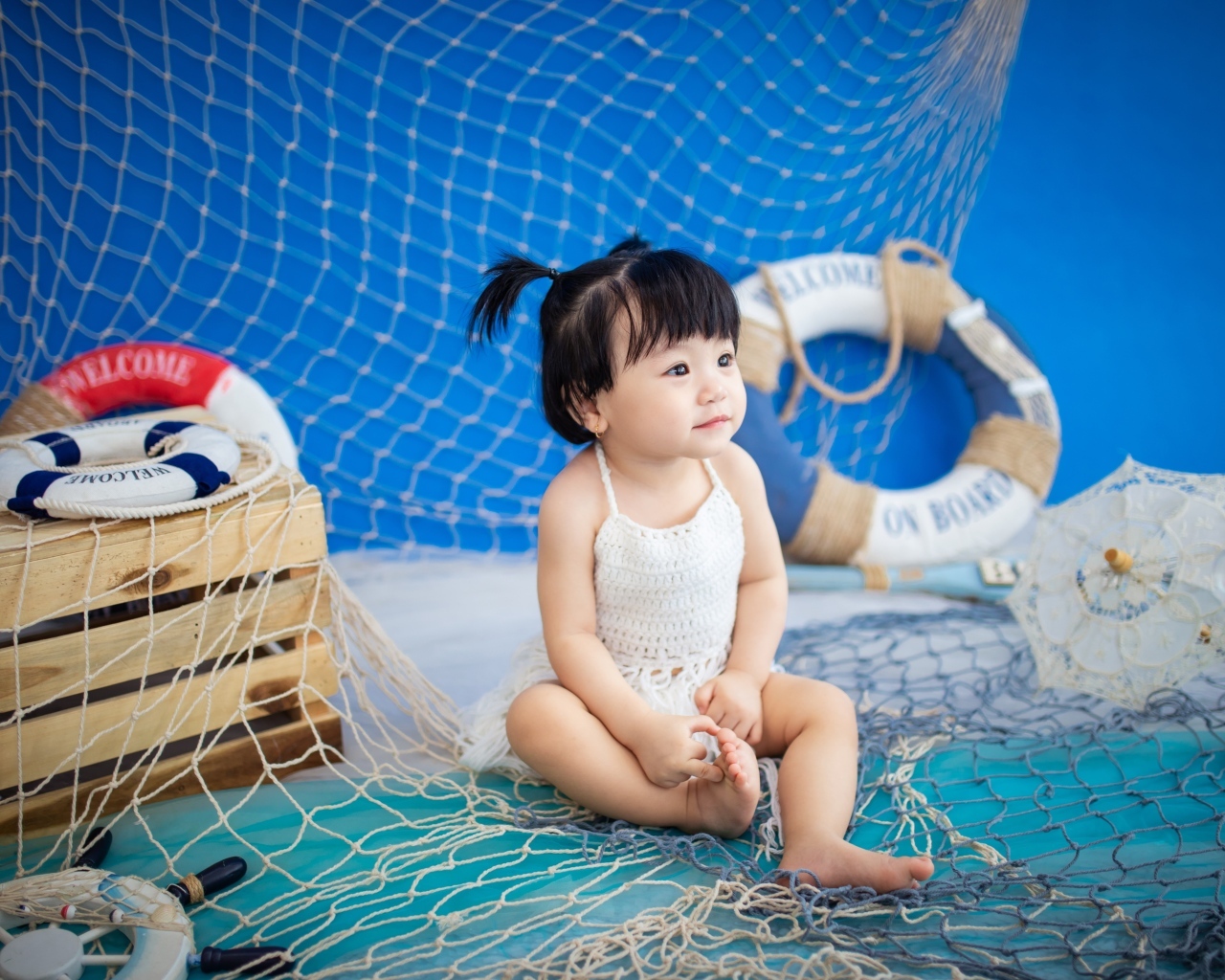 Маленькая девочка азиатка со  спасательным кругом и сетью 