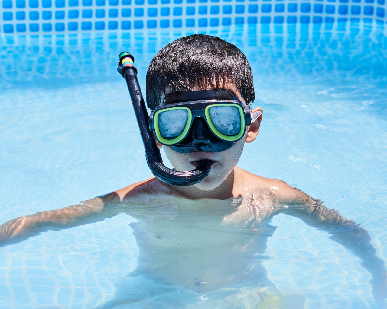 Маленький мальчик в маске в бассейне