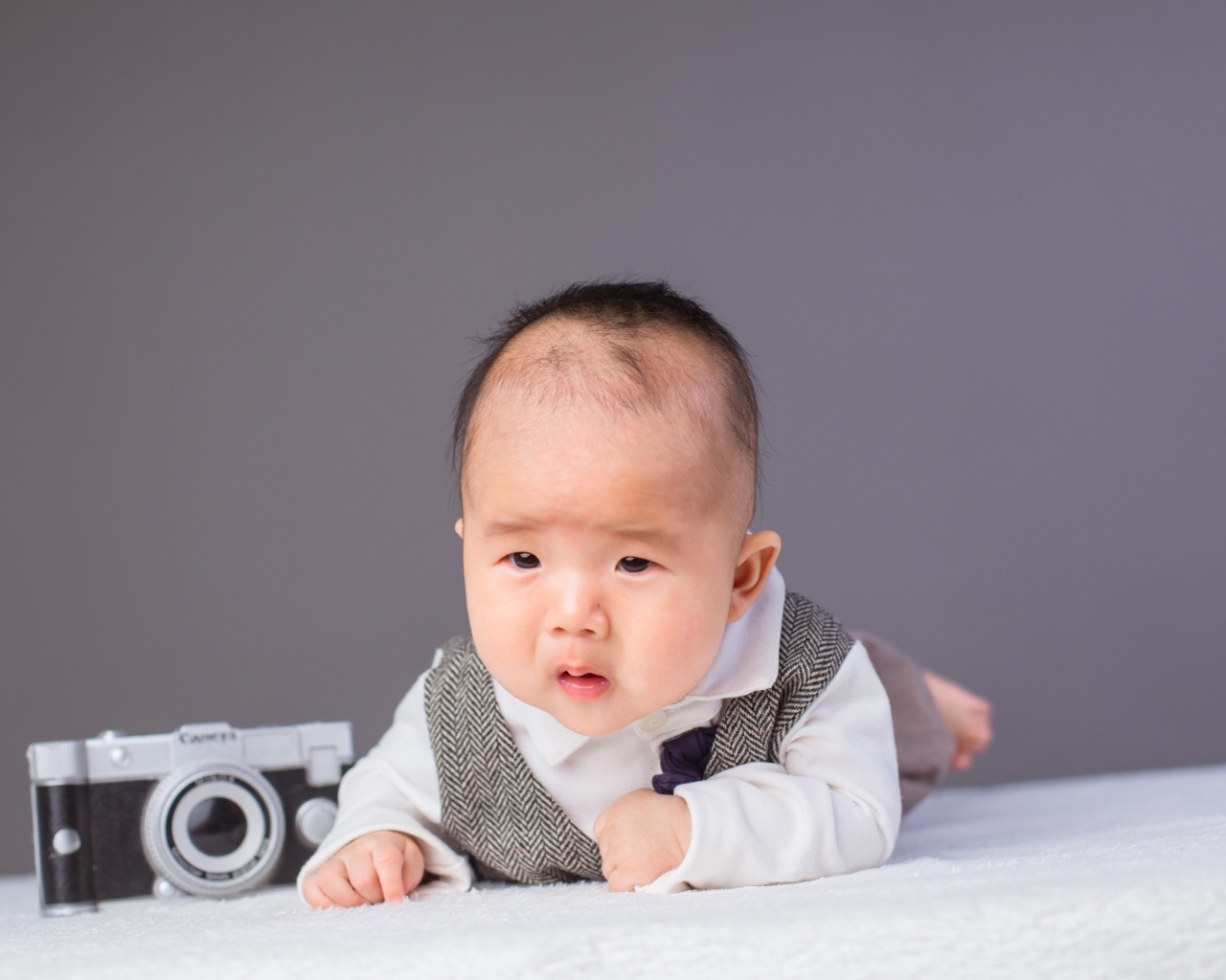 Маленький мальчик в костюме с фотоаппаратом