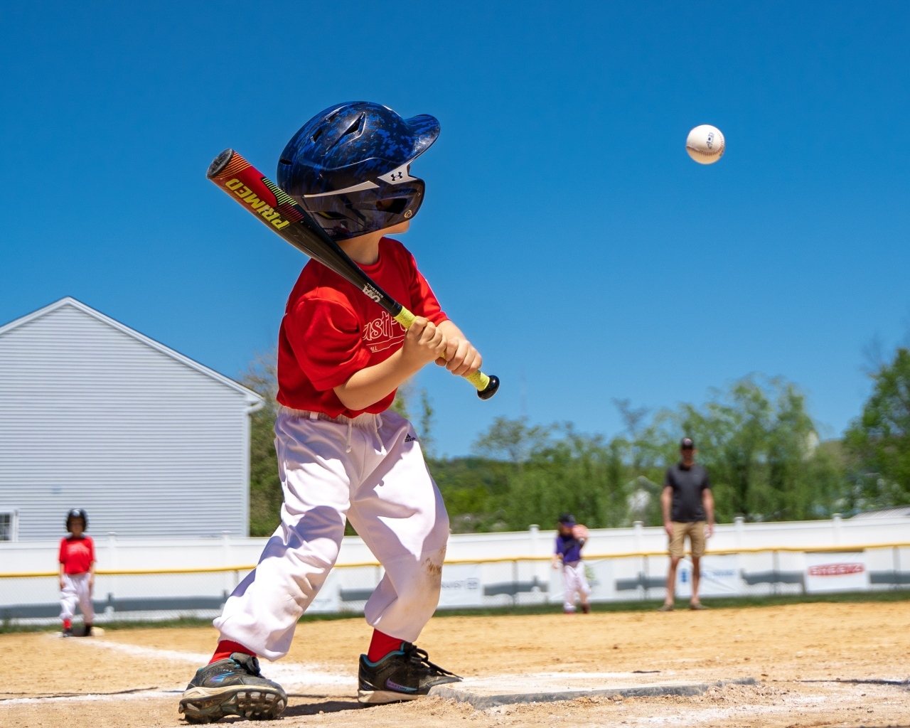 Маленький мальчик играет в бейсбол 