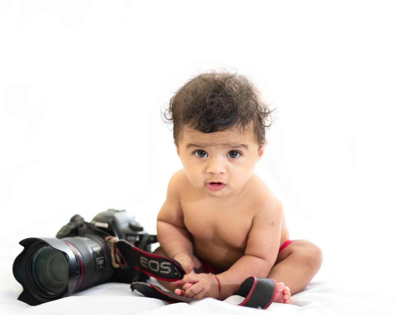 Маленький мальчик с фотоаппаратом на белом фоне