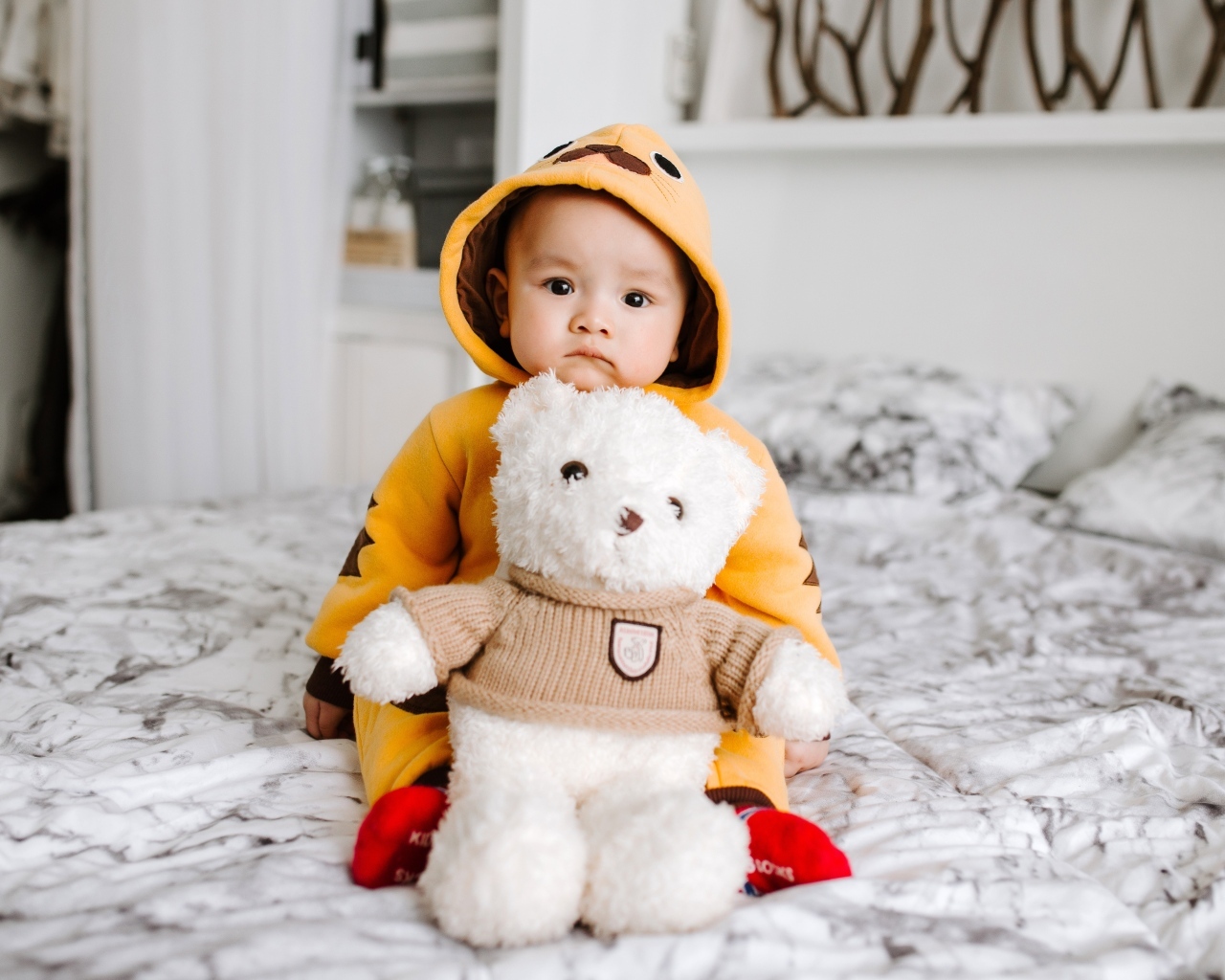 Маленький ребенок с игрушкой на кровати 