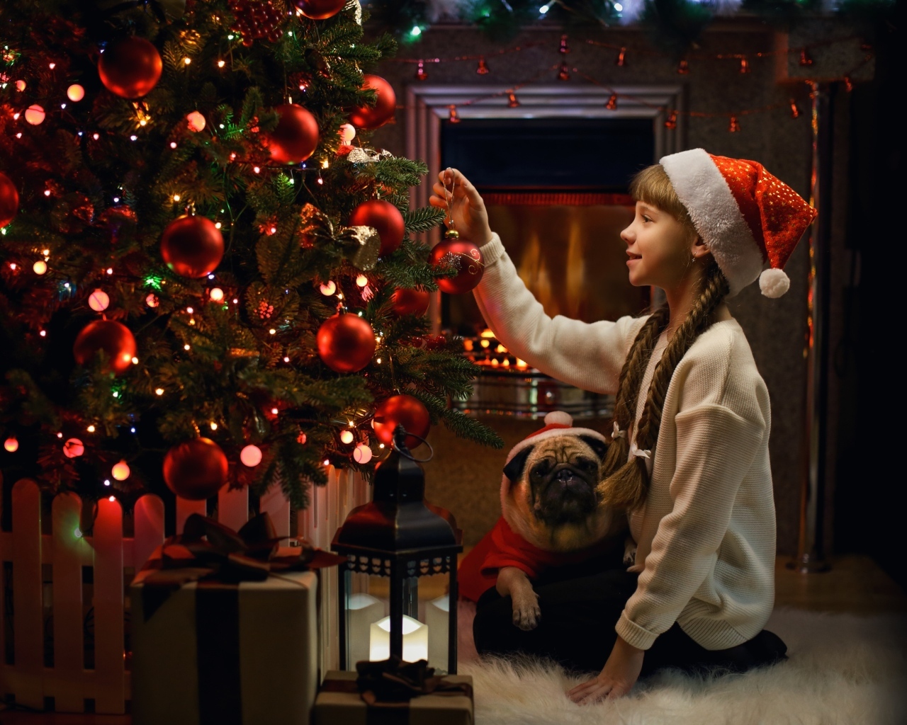 Маленькая девочка наряжает Рождественскую ель