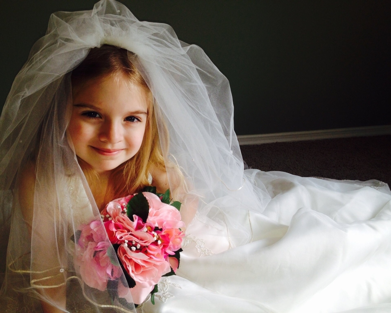 Маленькая девочка в костюме невесты с букетом