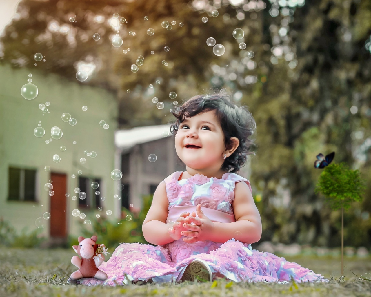 Маленькая девочка радуется мыльным пузырям
