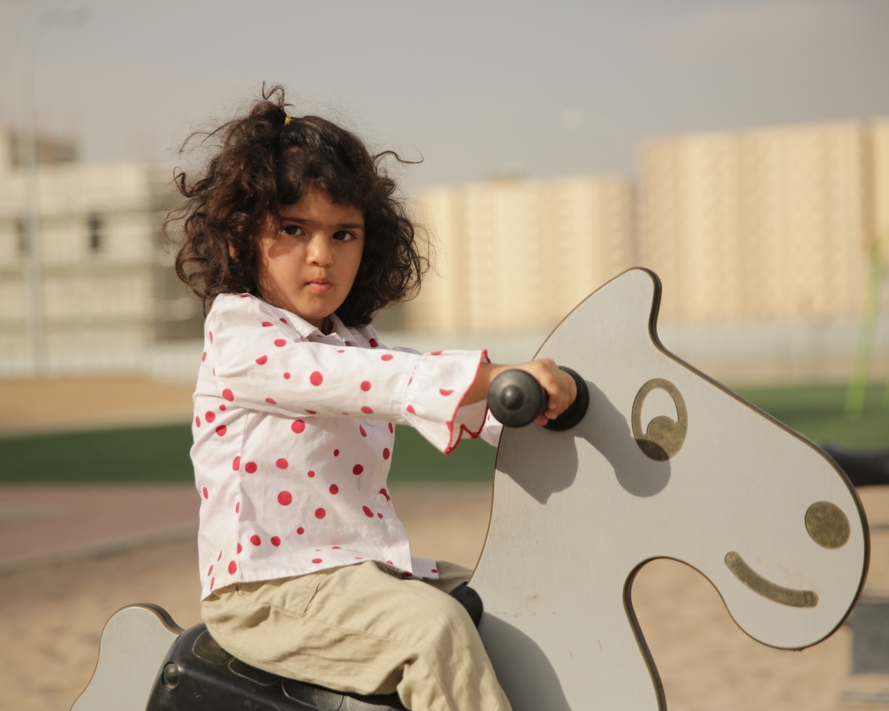Маленькая девочка на деревянной лошади