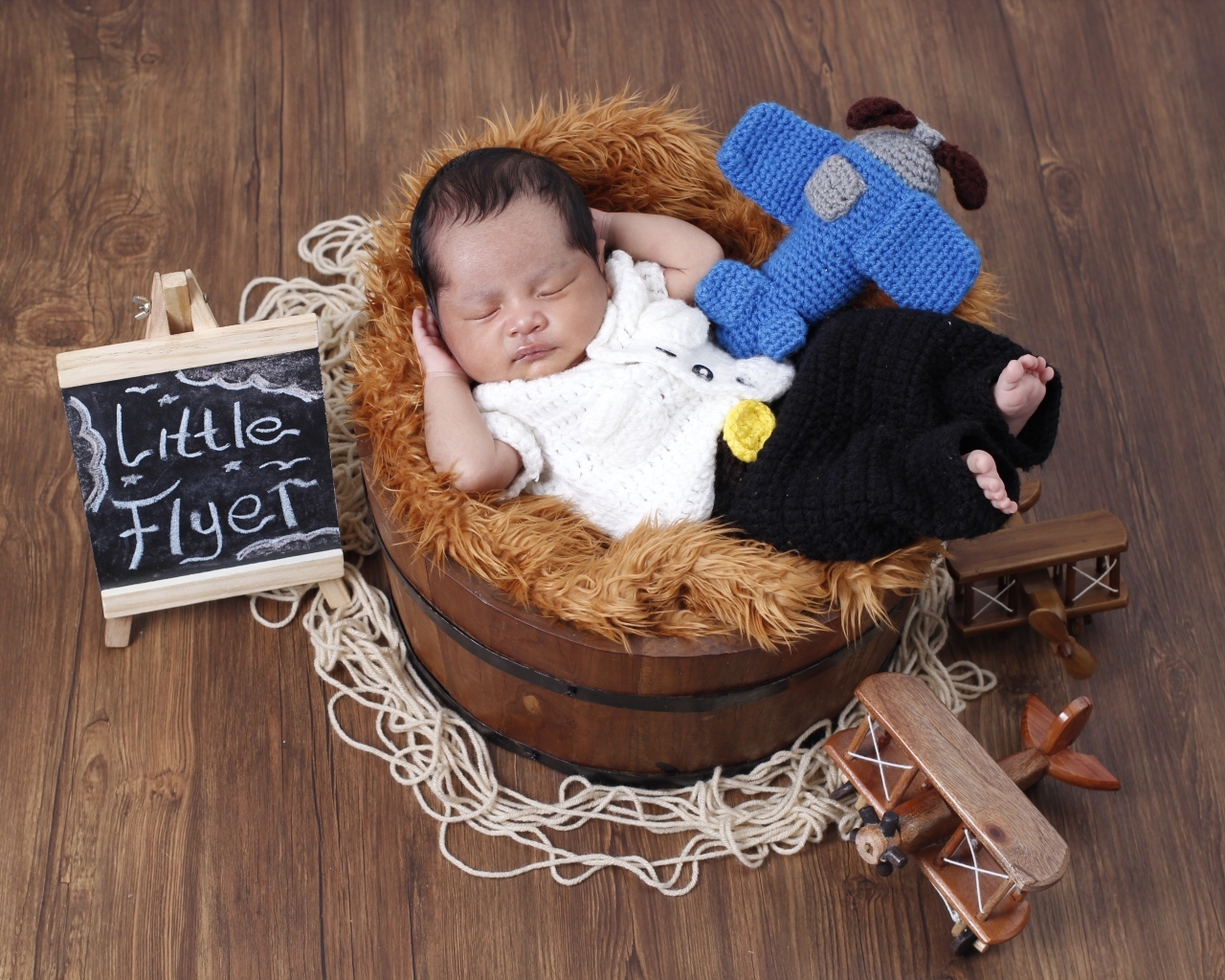 Маленький новорожденный малыш спит в бочке 