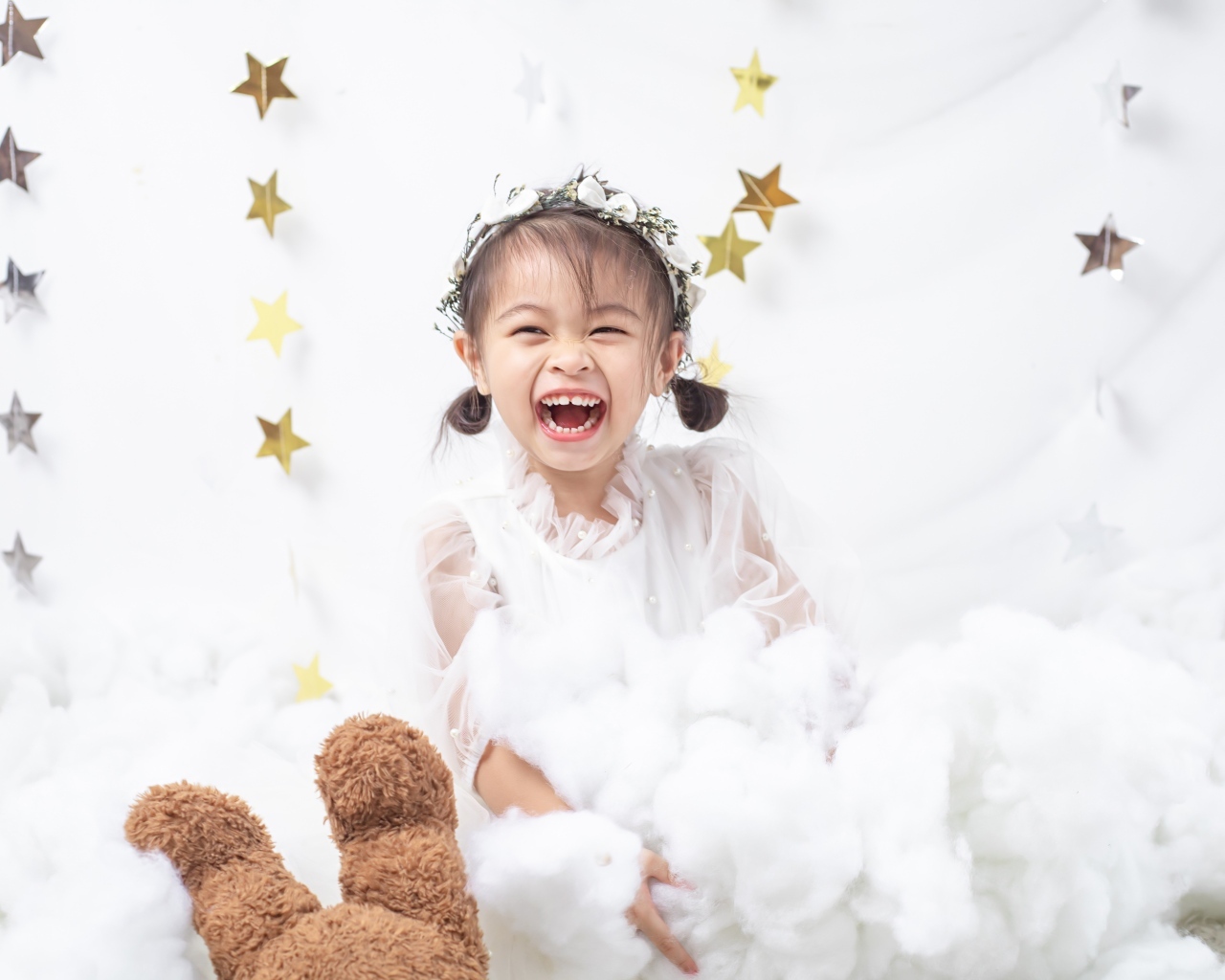 Маленькая улыбающаяся девочка азиатка в белом платье