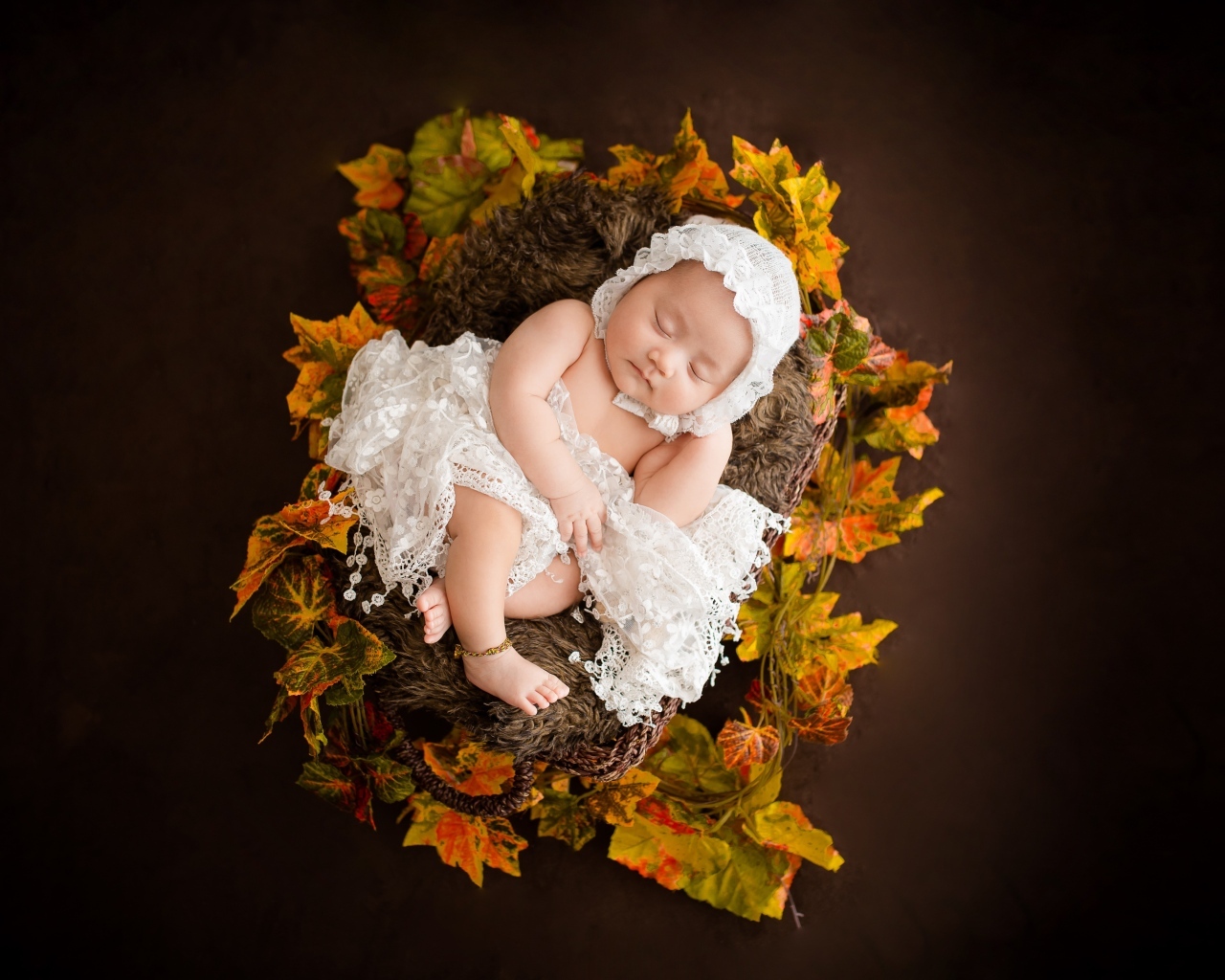 Новорожденная девочка в колыбели в белом костюме