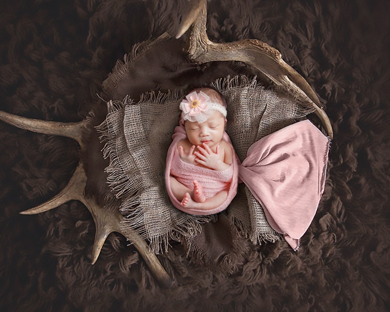 Новорожденная девочка на покрывале с рогами