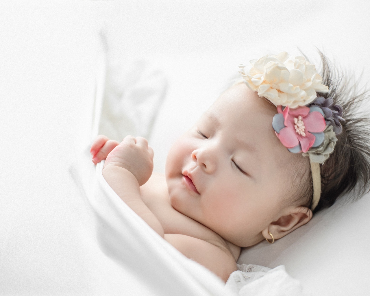 Новорожденная девочка с повязкой на голове