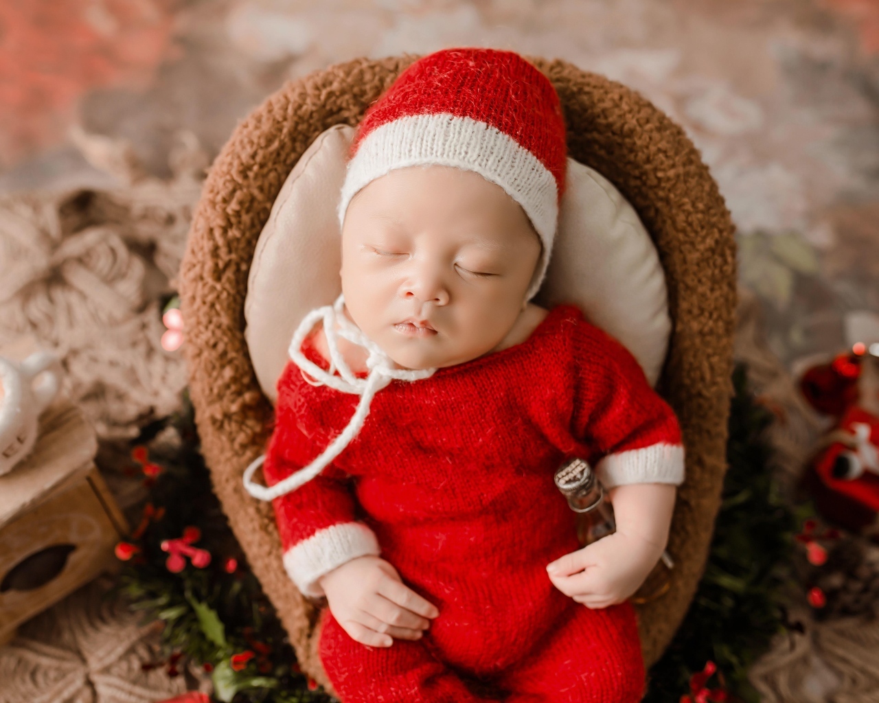 Новорожденный малыш в красном вязаном костюме