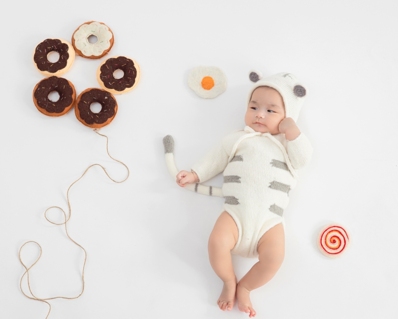Новорожденный ребенок в костюме с пончиками