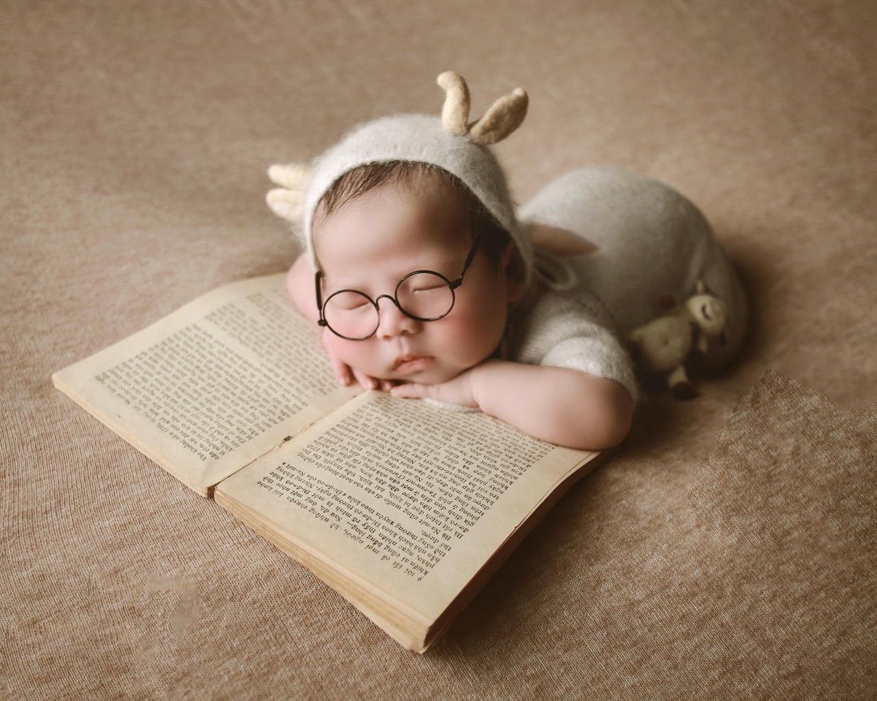 Новорожденный ребенок спит с книгой