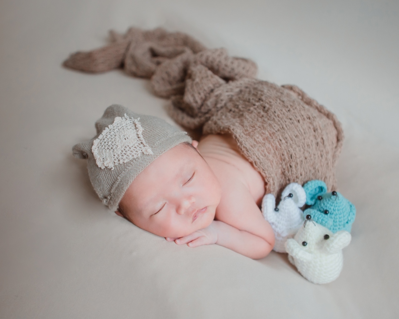 Новорожденный малыш спит на сером покрывале