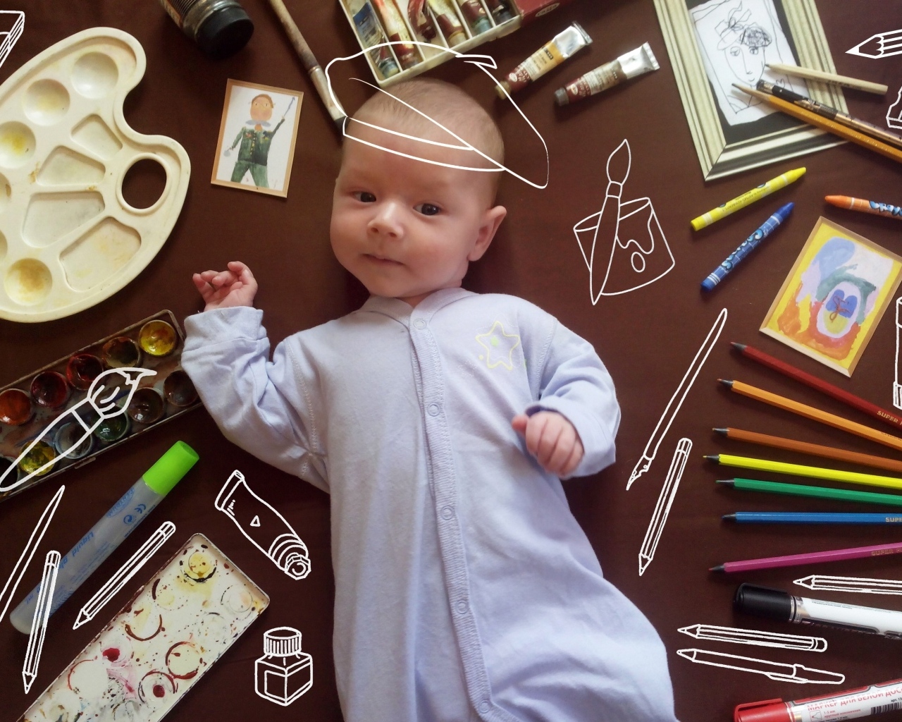 Новорожденный ребенок с канцелярскими предметами