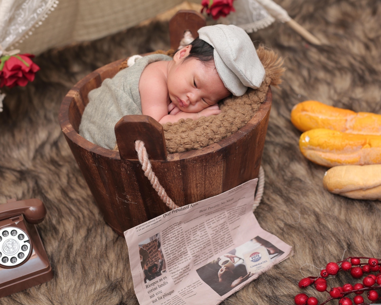 Новорожденный маленький мальчик в деревянном ведре на фотосессии 