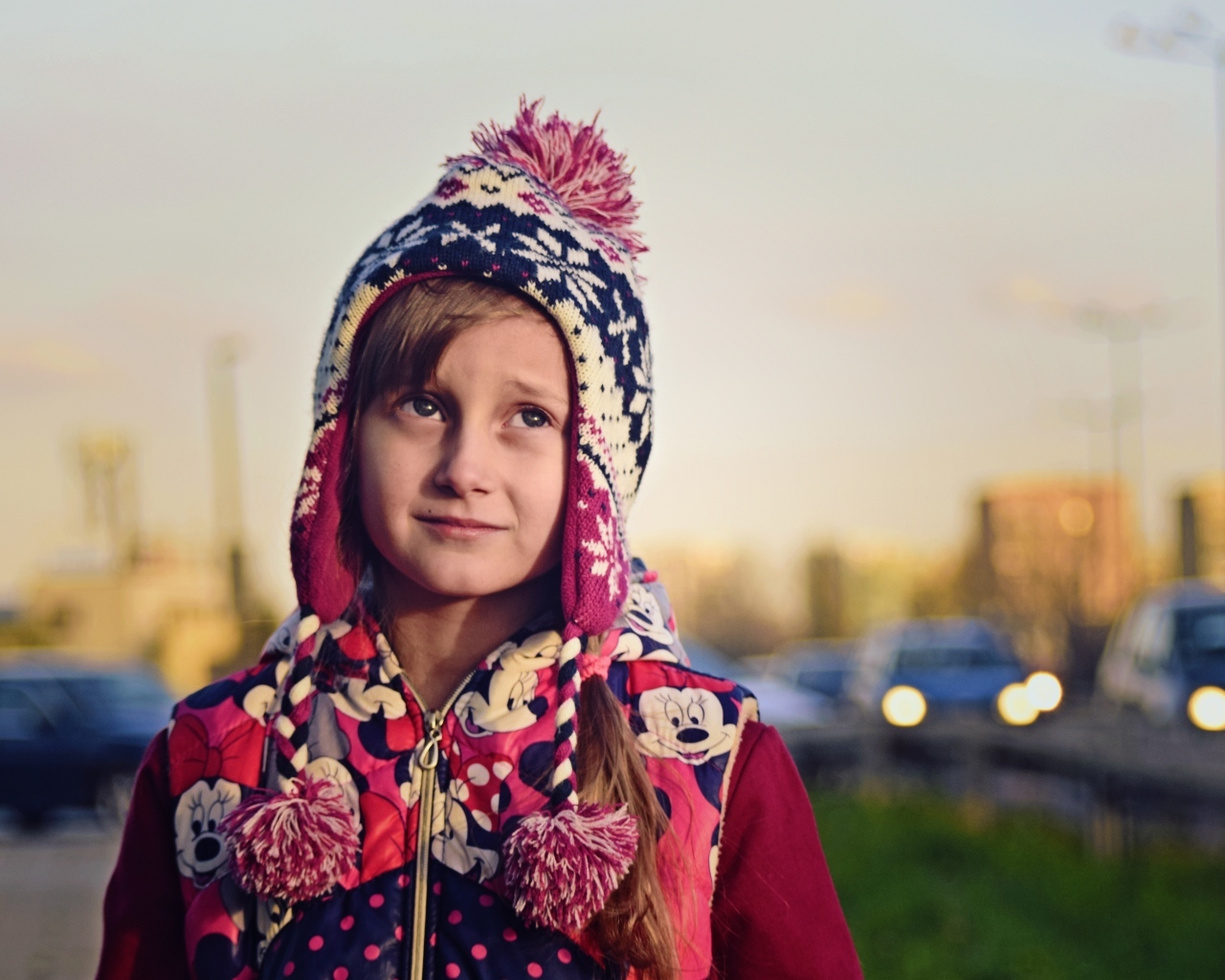 Грустная девочка в теплой шапке на улице