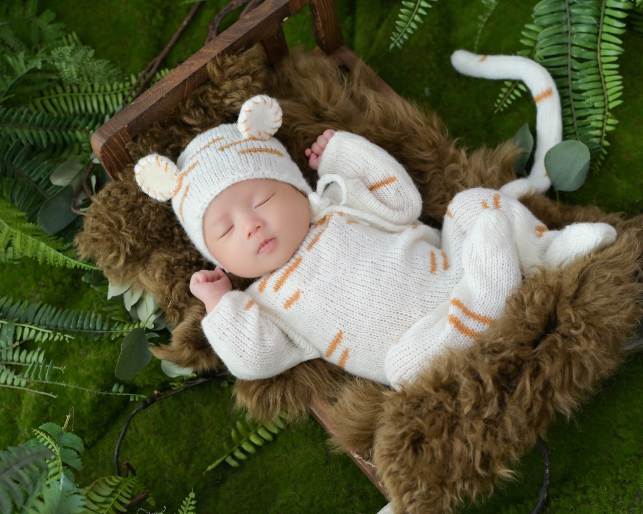 Спящий новорожденный ребенок в костюме тигренка