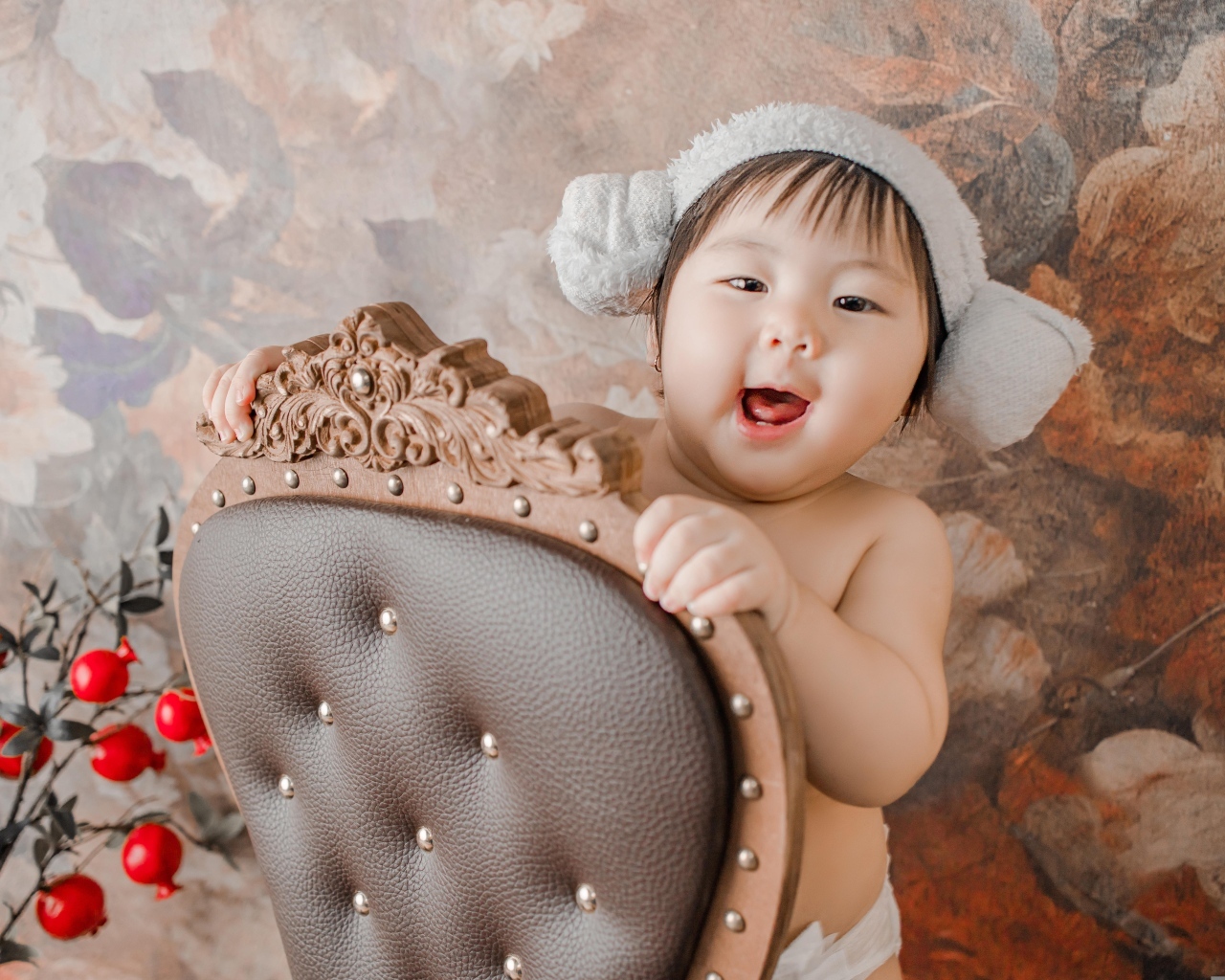 Улыбающийся ребенок азиат стоит у кресла