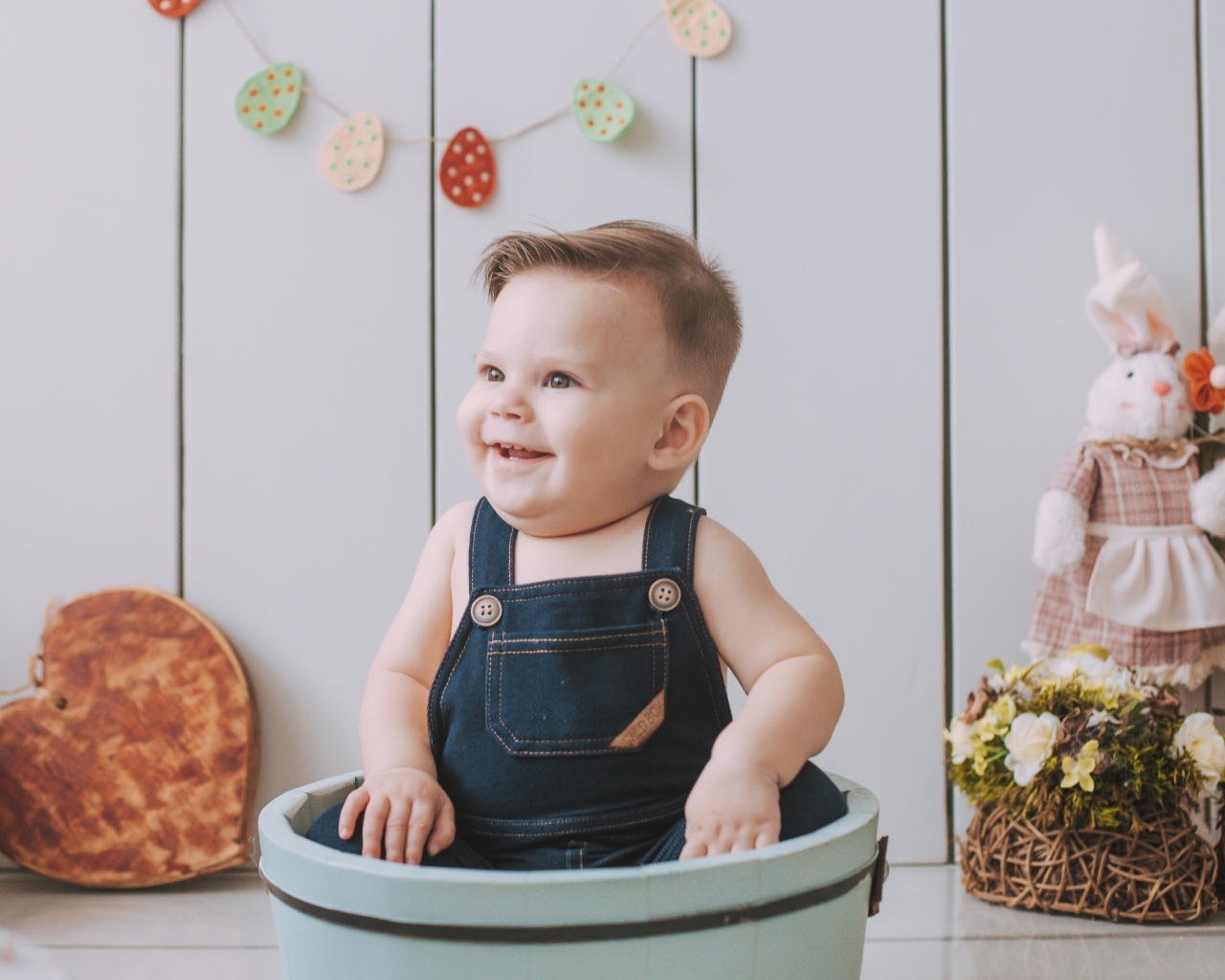 Улыбающийся ребенок сидит в ведре 