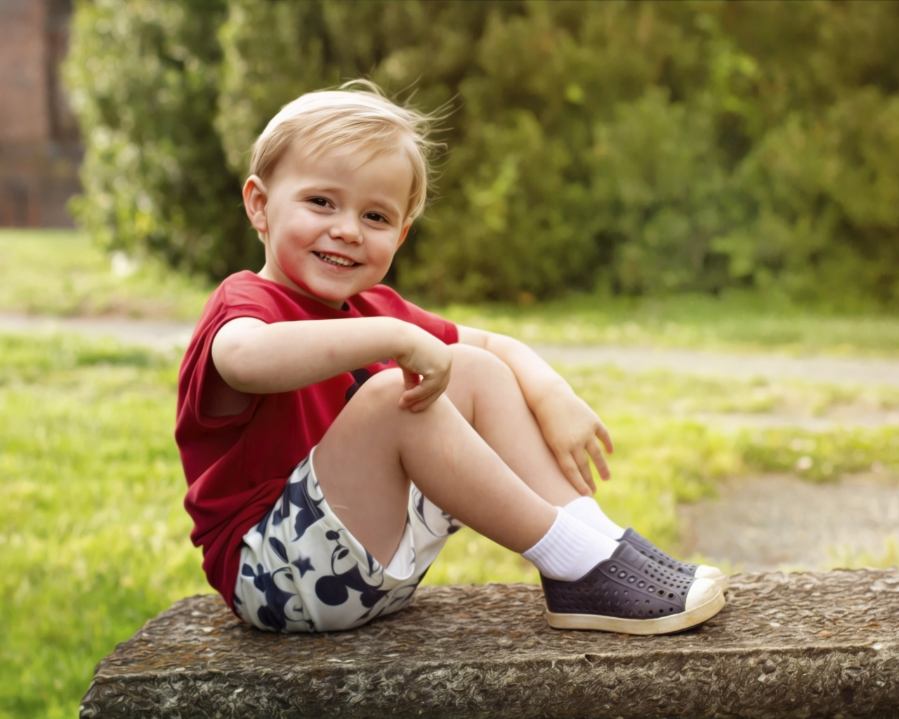 Улыбающийся маленький мальчик в красной футболке