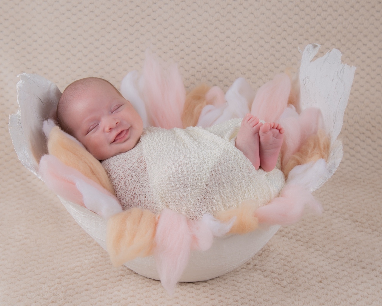 Улыбающийся спящий новорожденный малыш